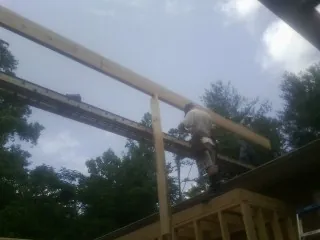 Carpenter setting a ridge beam over a new addition frame — Ice Dam Removal by Roofing Brothers in Wilberforce