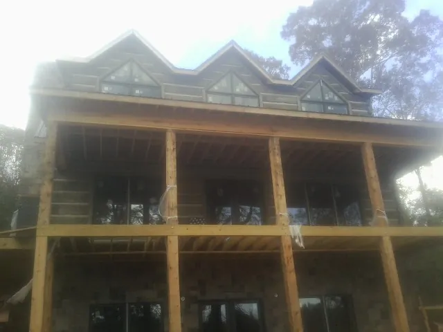Dormers and porch framing on a large log home under construction — Roof Coating work by our crew in Wilberforce