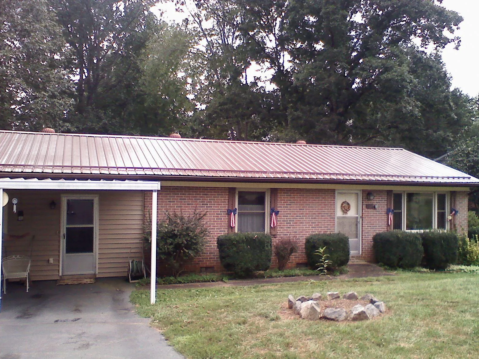 Bronze metal roof and carport on a brick ranch home — Roof Repair work by our crew in Wilberforce
